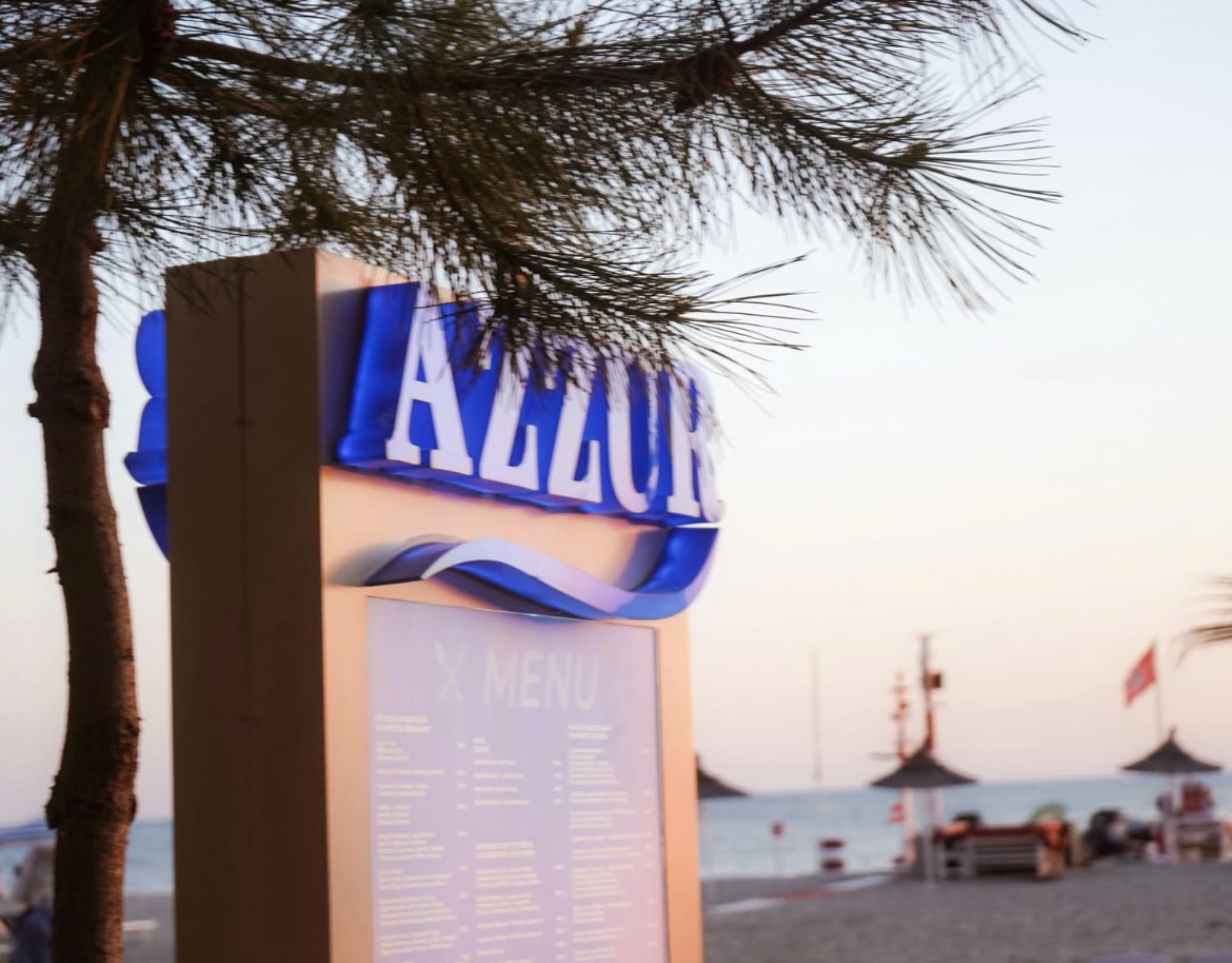 Azzur sign at sunset framed by pine branches